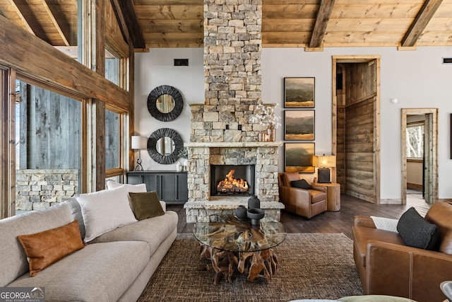 living area with baseboards, beamed ceiling, wooden ceiling, a fireplace, and wood finished floors