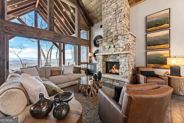 living area featuring high vaulted ceiling, beam ceiling, a fireplace, wood-type flooring, and wooden ceiling