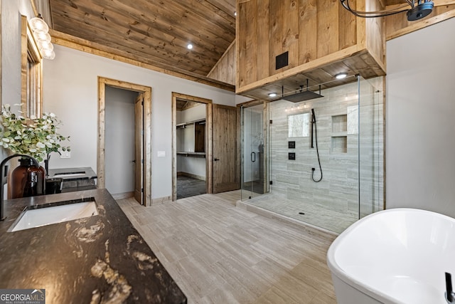 bathroom featuring vanity, lofted ceiling, a freestanding bath, a shower stall, and wood ceiling