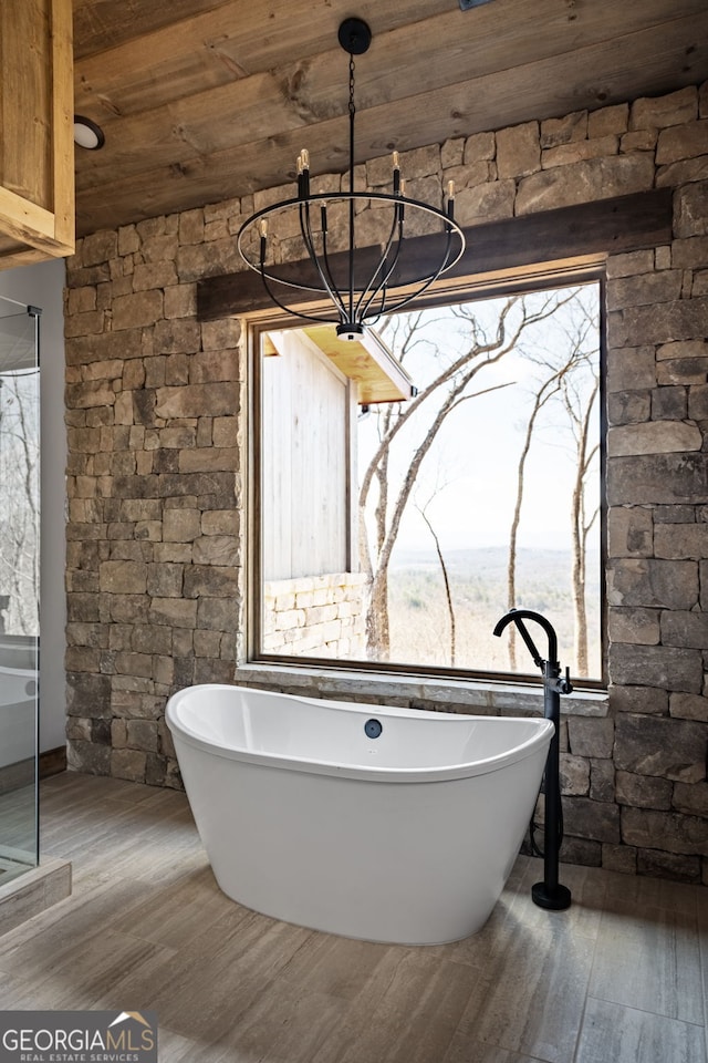 bathroom with a freestanding tub, wood finished floors, and wooden ceiling