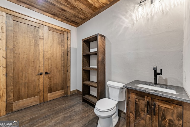 bathroom with toilet, wood finished floors, baseboards, wood ceiling, and vanity