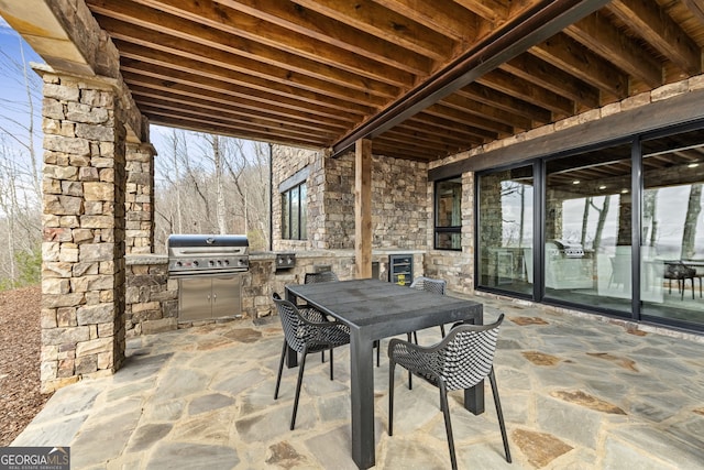 view of patio featuring grilling area, outdoor dining space, and exterior kitchen