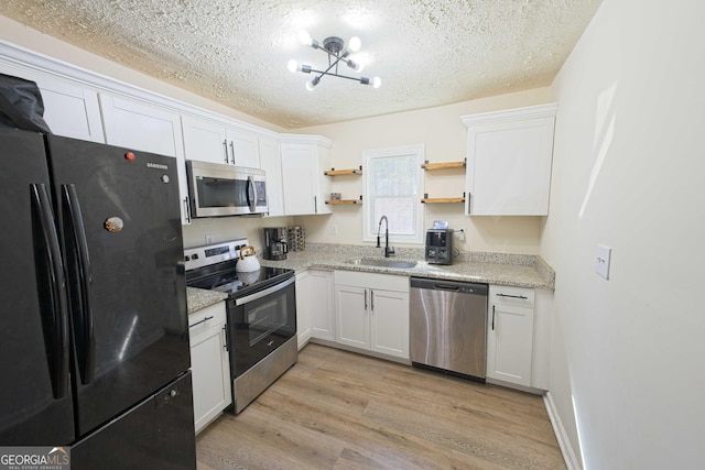 kitchen with open shelves, light wood-style flooring, a sink, appliances with stainless steel finishes, and white cabinetry