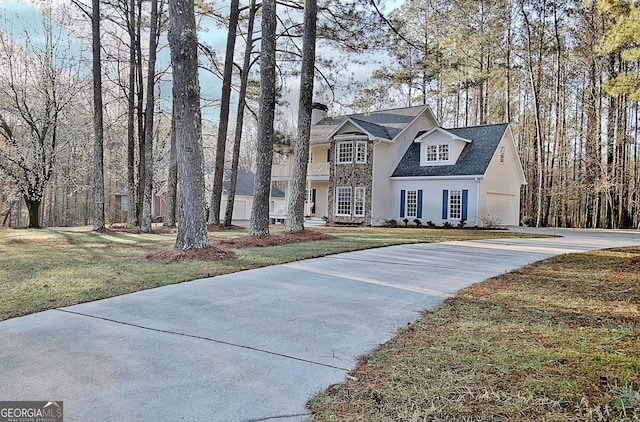 view of front of home with a garage, stucco siding, concrete driveway, and a front lawn