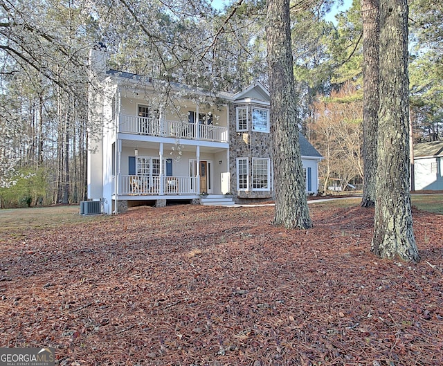 view of front of house with a balcony, covered porch, and central AC