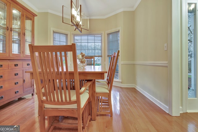 dining room featuring a chandelier, crown molding, and light wood finished floors