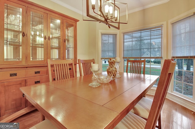 dining space featuring an inviting chandelier, light wood-style floors, and ornamental molding