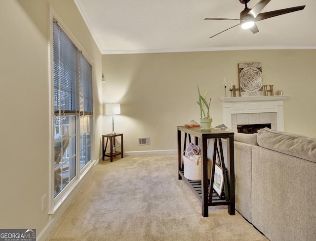 sitting room featuring visible vents, carpet floors, a fireplace, ornamental molding, and ceiling fan