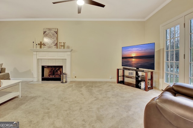 carpeted living area featuring ceiling fan, baseboards, ornamental molding, and a fireplace