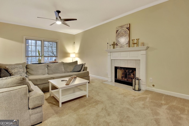 living area with light colored carpet, ornamental molding, a ceiling fan, and a tile fireplace