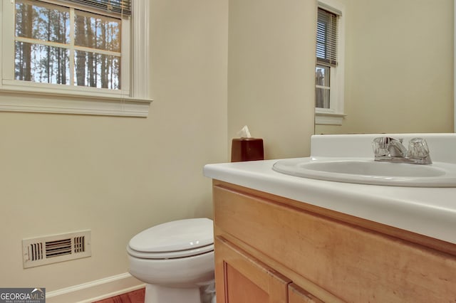 bathroom with vanity, toilet, and visible vents