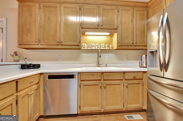 kitchen with visible vents, light brown cabinets, light countertops, appliances with stainless steel finishes, and a sink