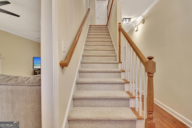 stairs with ceiling fan, baseboards, wood finished floors, and ornamental molding