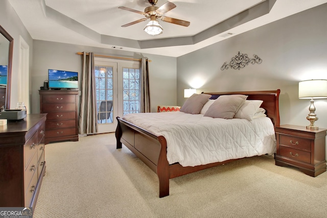 bedroom featuring visible vents, a ceiling fan, access to outside, a raised ceiling, and light colored carpet