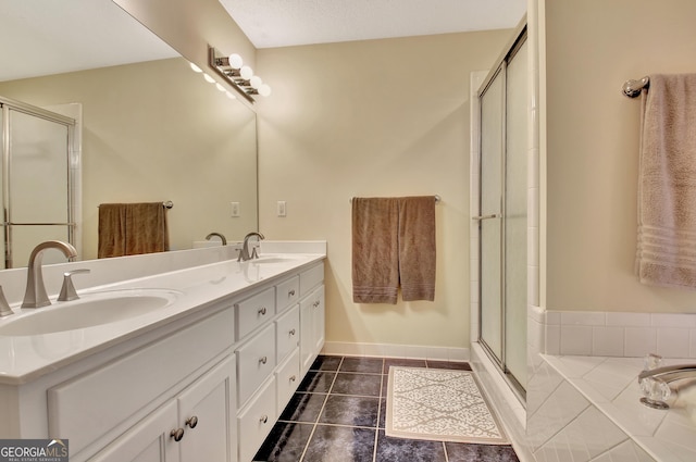 bathroom with tile patterned flooring, an enclosed shower, double vanity, and a sink