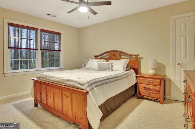 bedroom with visible vents, light carpet, baseboards, and a ceiling fan