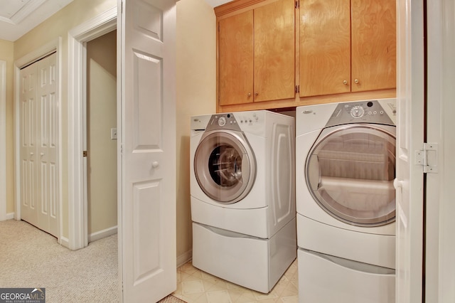 laundry room featuring baseboards, cabinet space, and washing machine and dryer