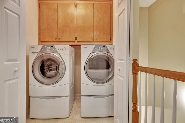 clothes washing area featuring cabinet space and washing machine and clothes dryer