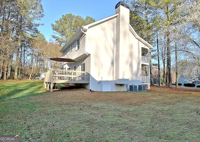 view of side of property featuring a yard, cooling unit, a wooden deck, crawl space, and a chimney