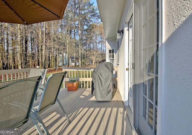 wooden deck with grilling area and outdoor dining area