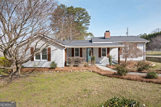 ranch-style home with a chimney and a front lawn