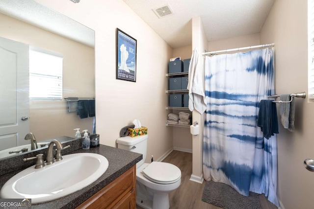 bathroom with visible vents, toilet, a shower with curtain, wood finished floors, and vanity