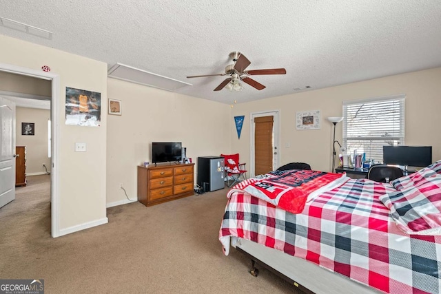 bedroom featuring a textured ceiling, attic access, and carpet floors