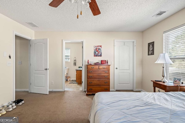 bedroom with visible vents, carpet floors, a textured ceiling, and baseboards