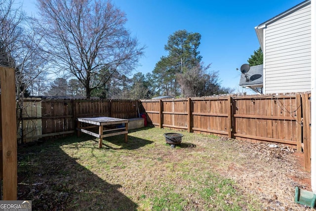 view of yard featuring a fire pit and a fenced backyard