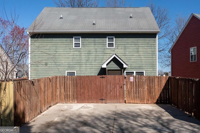 rear view of house featuring a gate and fence private yard