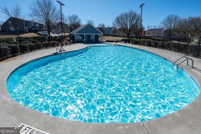 pool with a patio area and fence