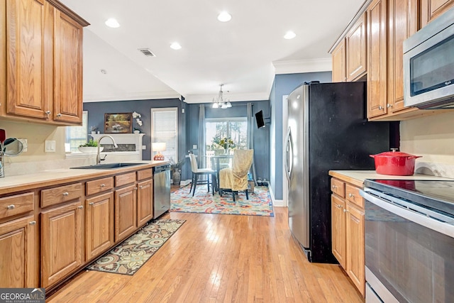 kitchen featuring visible vents, light countertops, appliances with stainless steel finishes, an inviting chandelier, and a sink