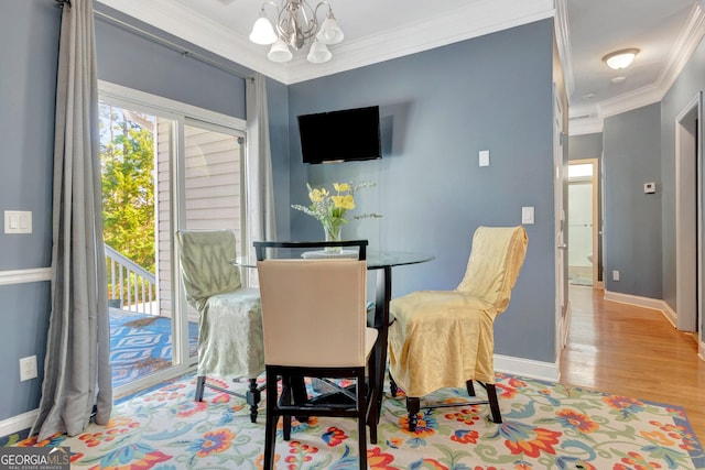 dining area featuring a notable chandelier, wood finished floors, baseboards, and ornamental molding