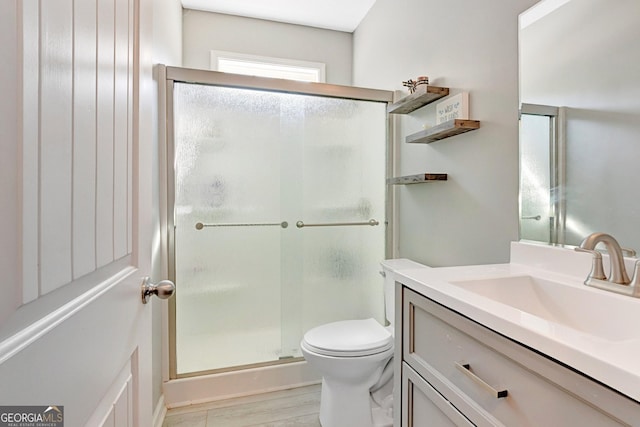 bathroom featuring vanity, toilet, and a stall shower