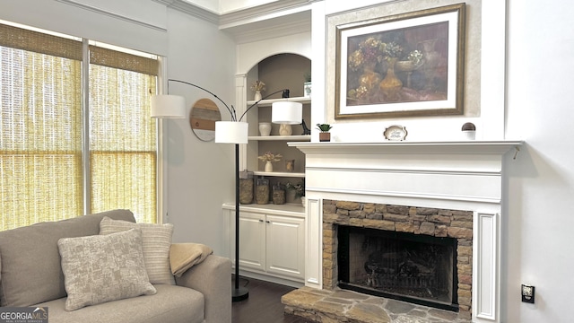 living room with wood finished floors, a fireplace, and crown molding