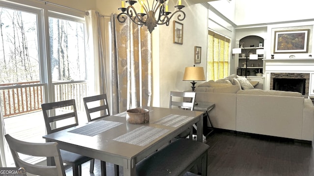 dining space with a chandelier, dark wood finished floors, a fireplace, and a wealth of natural light