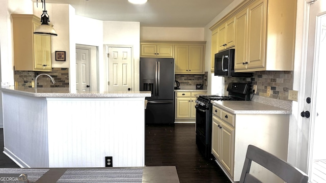 kitchen with dark wood-type flooring, black appliances, a peninsula, and light countertops