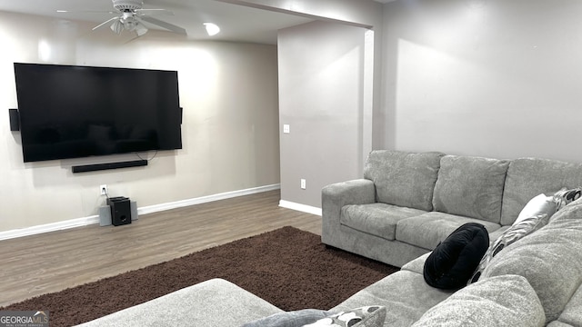 living area with wood finished floors, baseboards, and ceiling fan