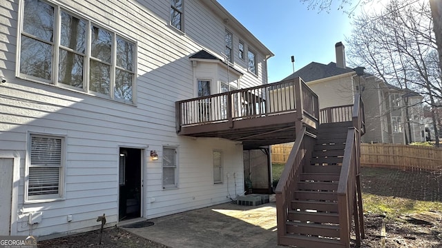 rear view of house with stairs, a patio area, a deck, and fence