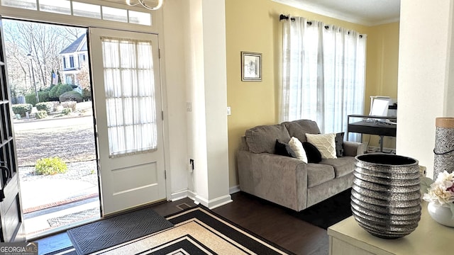 entryway with crown molding, dark wood-style floors, and baseboards