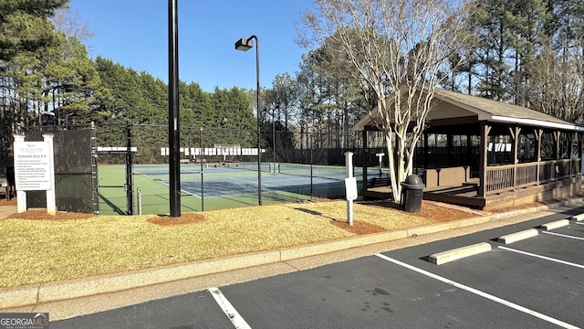 view of tennis court with a gazebo and fence