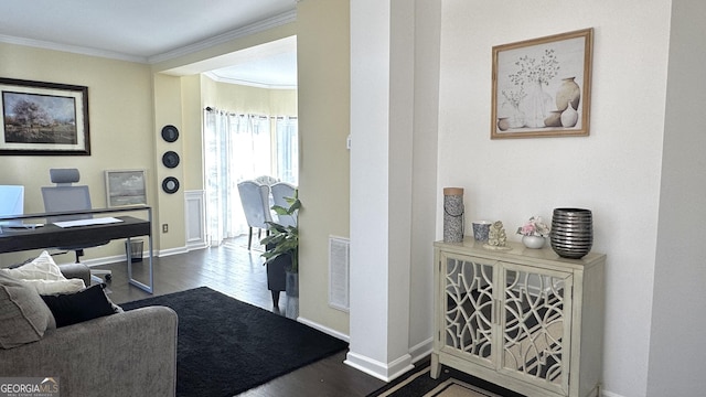 interior space with visible vents, baseboards, wood finished floors, and crown molding