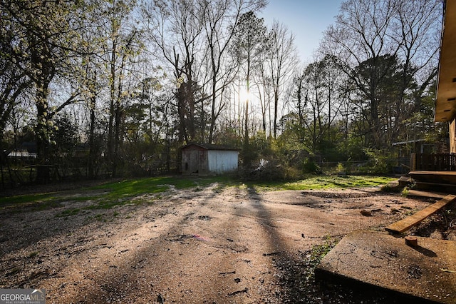 view of yard featuring an outbuilding, a shed, and driveway