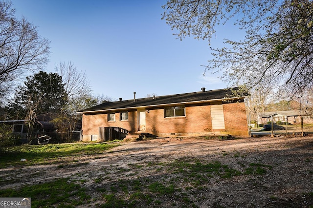 rear view of property with brick siding and fence