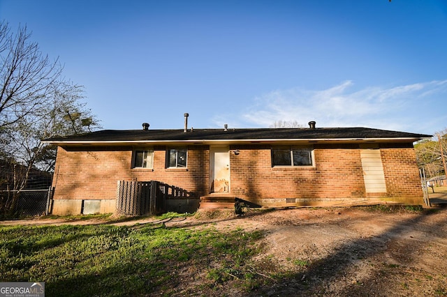 view of front facade featuring brick siding, crawl space, and fence