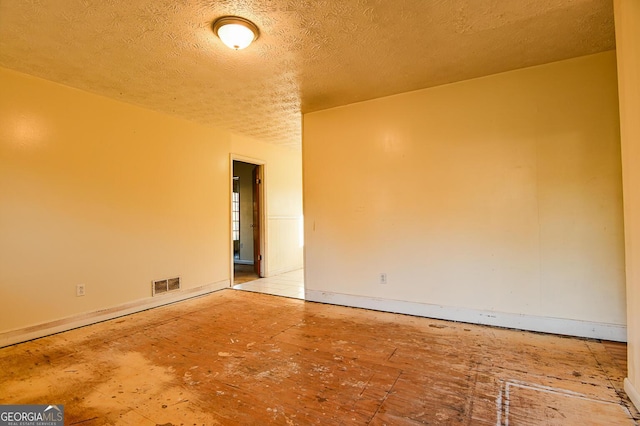 unfurnished room with visible vents and a textured ceiling