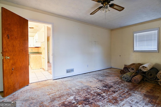 unfurnished room featuring baseboards, visible vents, ceiling fan, a textured ceiling, and crown molding