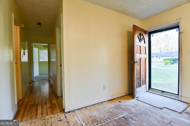 entryway featuring a textured ceiling and baseboards