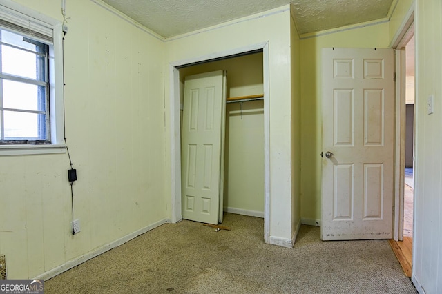 unfurnished bedroom featuring a closet, baseboards, a textured ceiling, and carpet flooring