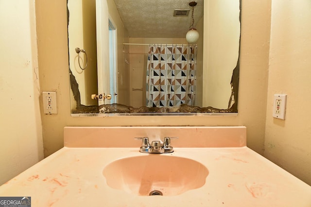 bathroom with visible vents, a textured ceiling, and vanity